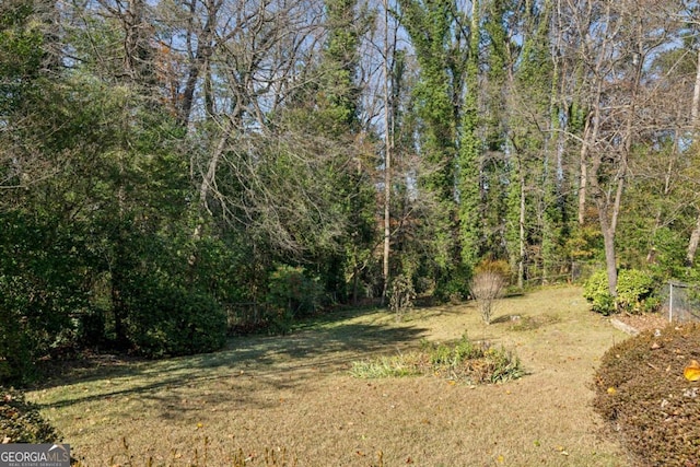 view of yard with a view of trees and fence