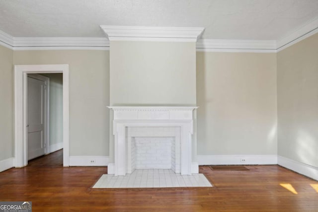 unfurnished living room with a tiled fireplace, crown molding, baseboards, and wood finished floors