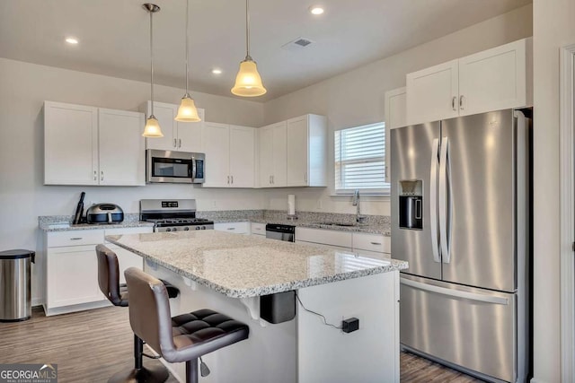 kitchen with sink, white cabinets, appliances with stainless steel finishes, and a center island