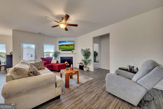 living room featuring ceiling fan and dark wood-type flooring