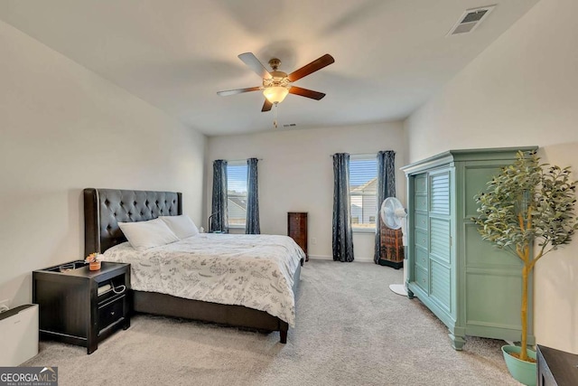 bedroom with light colored carpet, ceiling fan, and multiple windows