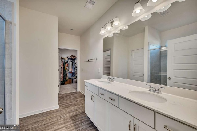 bathroom with a shower with door, vanity, and wood-type flooring