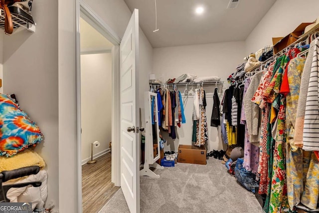 walk in closet featuring light colored carpet