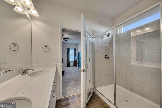 bathroom with hardwood / wood-style flooring, vanity, a shower with shower door, and plenty of natural light