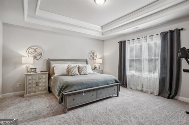 carpeted bedroom featuring ornamental molding and a raised ceiling