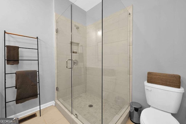 bathroom with toilet, a shower with shower door, and tile patterned floors