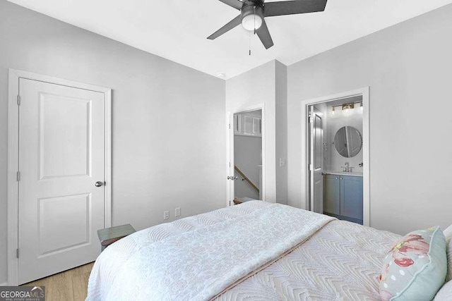 bedroom with ensuite bathroom, light wood-type flooring, ceiling fan, and sink