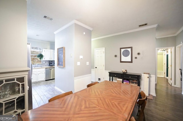 dining room with hardwood / wood-style flooring and crown molding