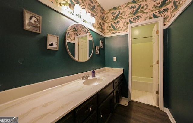 bathroom with a washtub, vanity, and hardwood / wood-style flooring