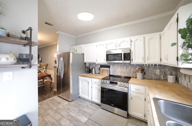 kitchen featuring stainless steel appliances, sink, white cabinetry, tasteful backsplash, and crown molding