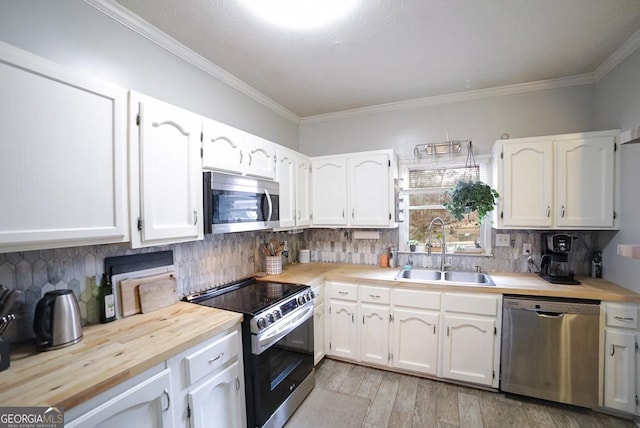 kitchen featuring stainless steel appliances, white cabinets, sink, and tasteful backsplash