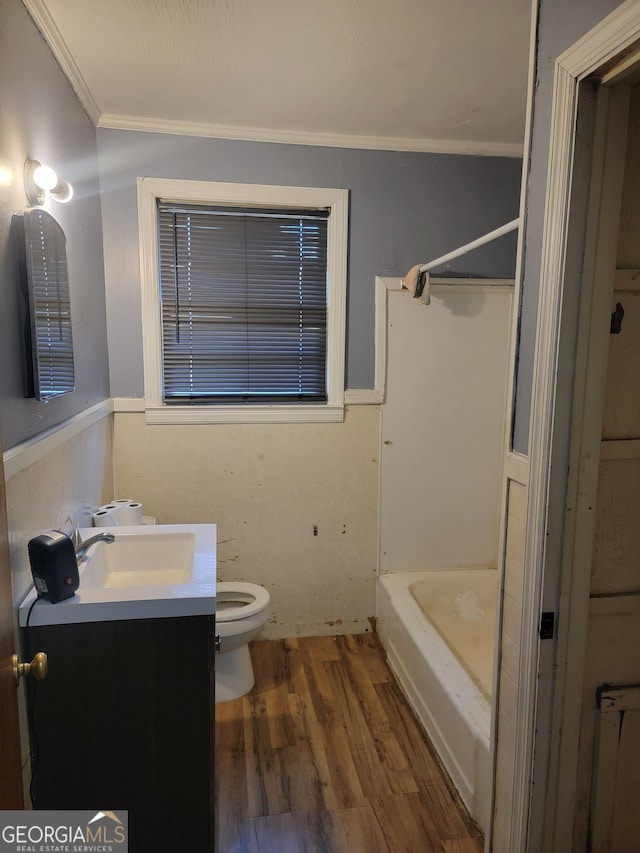 full bathroom featuring toilet, wood-type flooring, vanity, ornamental molding, and independent shower and bath