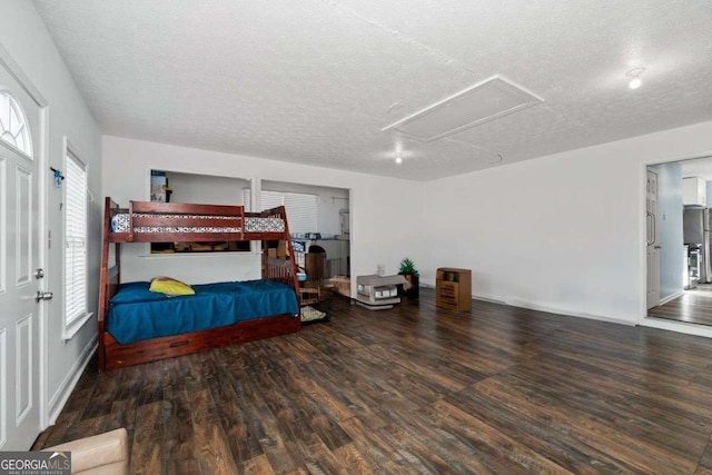 bedroom featuring a textured ceiling, dark hardwood / wood-style flooring, and multiple windows