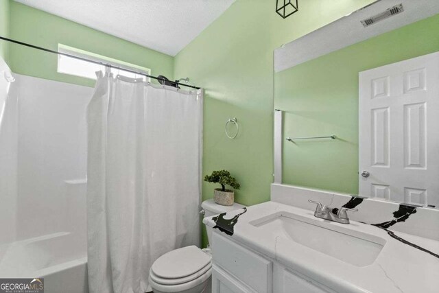 full bathroom featuring toilet, vanity, a textured ceiling, and shower / bath combination with curtain