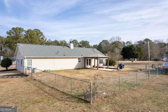 back of property with a lawn and a patio