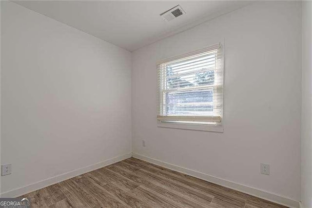 unfurnished room with hardwood / wood-style flooring