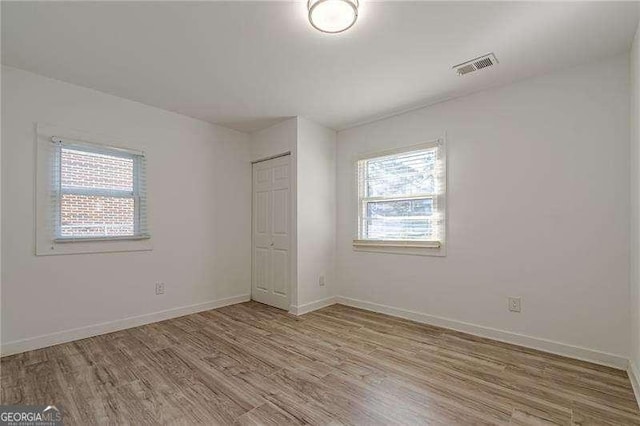 unfurnished bedroom featuring a closet and light hardwood / wood-style flooring