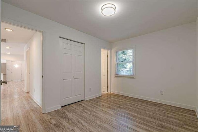 unfurnished bedroom featuring a closet and wood-type flooring