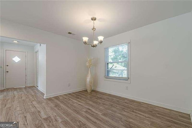 interior space with an inviting chandelier and hardwood / wood-style flooring