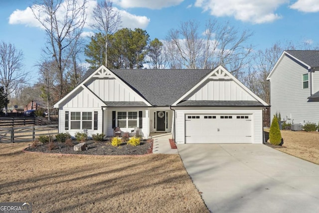 view of front of home featuring central AC, a front lawn, and a garage