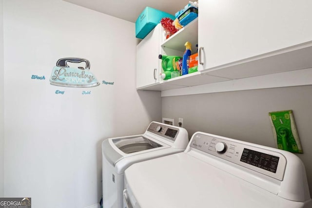 clothes washing area featuring cabinets and washing machine and clothes dryer