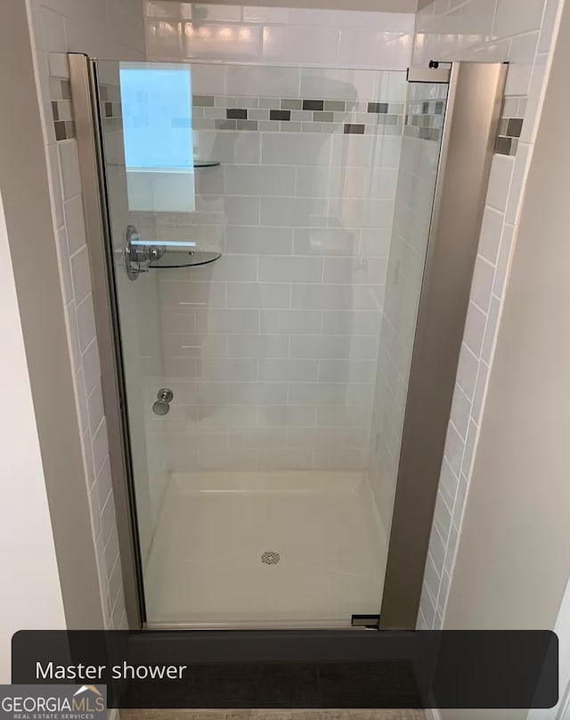 bathroom with a shower with door