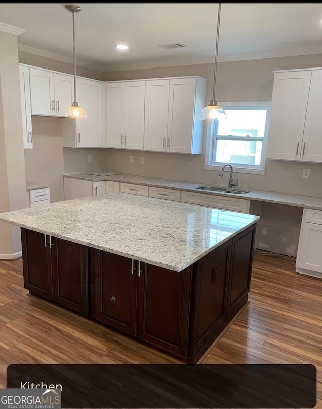 kitchen featuring white cabinets, dark brown cabinets, sink, and a kitchen island