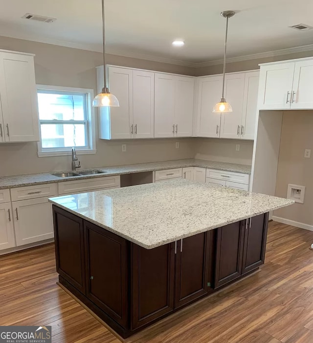 kitchen featuring sink, pendant lighting, and white cabinets