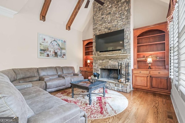 living room featuring built in shelves, beam ceiling, high vaulted ceiling, a fireplace, and hardwood / wood-style floors