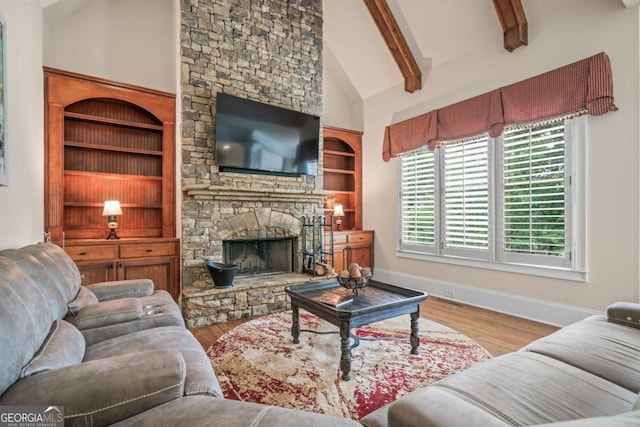 living room featuring beam ceiling, a stone fireplace, high vaulted ceiling, and light wood-type flooring