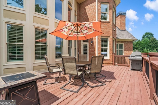 wooden deck featuring a grill