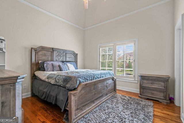 bedroom featuring dark wood-type flooring, ceiling fan, and ornamental molding