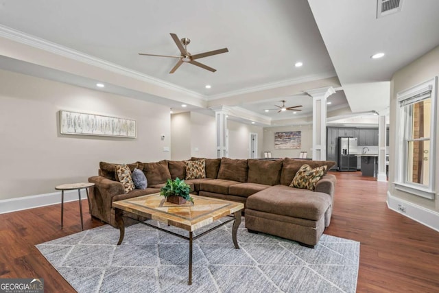 living room with hardwood / wood-style flooring, ornamental molding, decorative columns, and ceiling fan