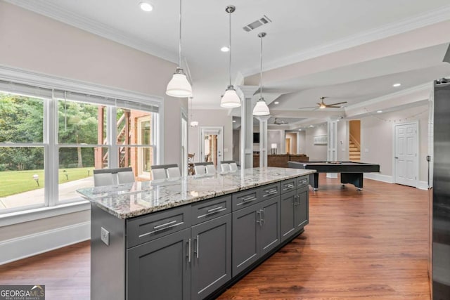 kitchen with decorative light fixtures, gray cabinets, ornamental molding, and a kitchen island