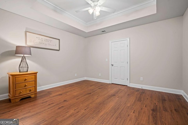 unfurnished room featuring hardwood / wood-style floors, a raised ceiling, and ceiling fan