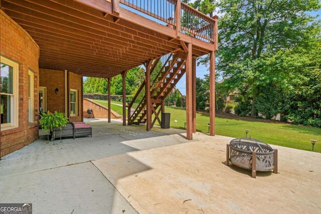 view of patio / terrace with a deck and an outdoor fire pit