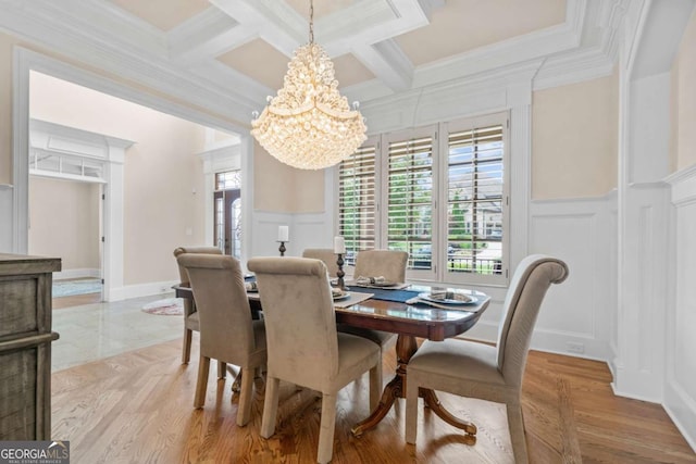 dining space with an inviting chandelier, crown molding, coffered ceiling, and beamed ceiling