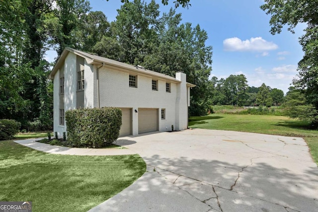 view of side of property featuring a garage and a lawn