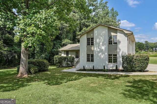 rear view of property featuring a lawn