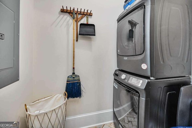 laundry room with stacked washer and clothes dryer and electric panel