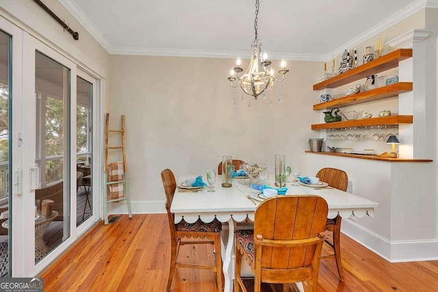 dining room with crown molding, light hardwood / wood-style flooring, and a chandelier