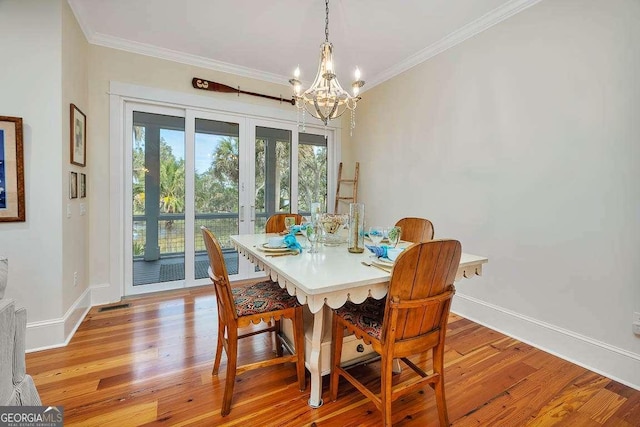 dining room featuring crown molding, a chandelier, and light wood-type flooring