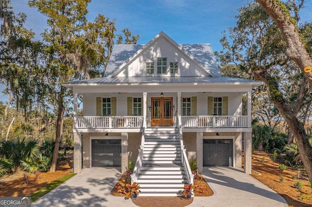 raised beach house with driveway, french doors, stairway, and a porch