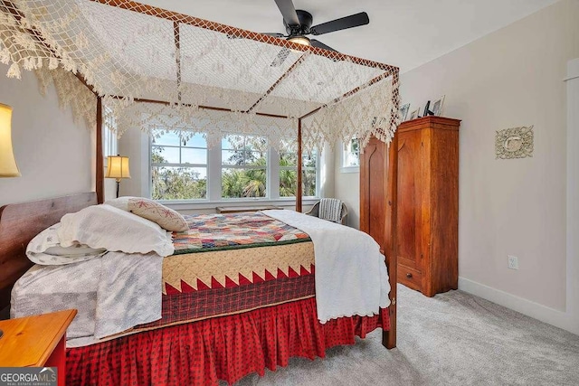 carpeted bedroom with ceiling fan and baseboards