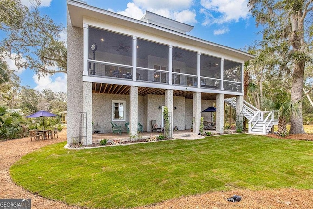 rear view of house featuring a sunroom, a patio, and stairway