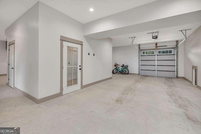 garage featuring a garage door opener and baseboards