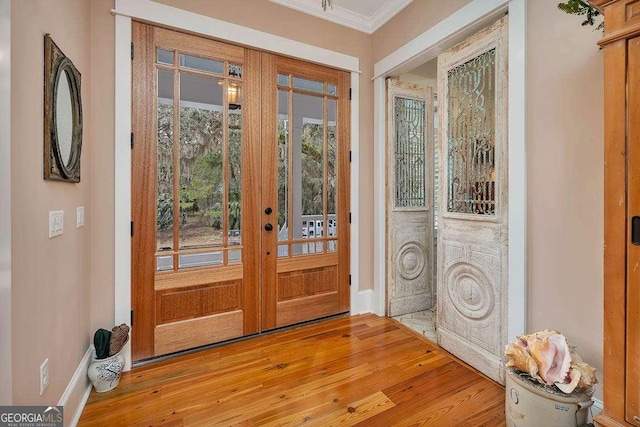 doorway to outside with ornamental molding, light hardwood / wood-style floors, and french doors