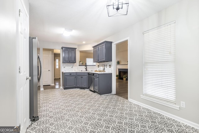 kitchen with stainless steel appliances, decorative backsplash, sink, and gray cabinets