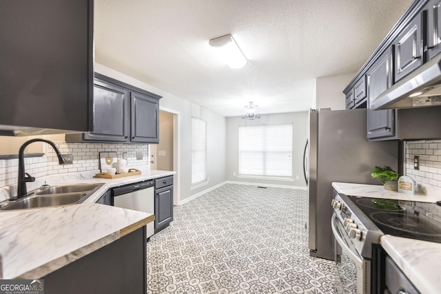 kitchen with sink, decorative backsplash, range hood, and appliances with stainless steel finishes