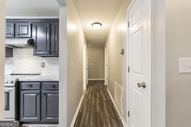 hall with a textured ceiling and dark wood-type flooring